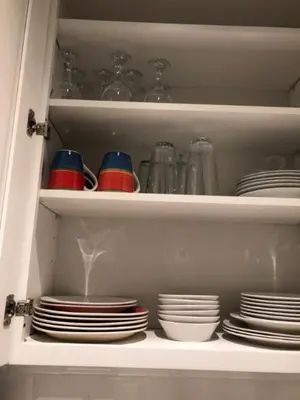 a cabinet filled with plates and bowls and dishes at Sandy's Place NYC 1 in Brooklyn