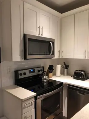 a kitchen with a stove and a microwave at Sandy's Place NYC 1 in Brooklyn