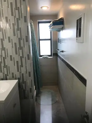 a bathroom with a shower and a sink and a window at Sandy's Place NYC 1 in Brooklyn