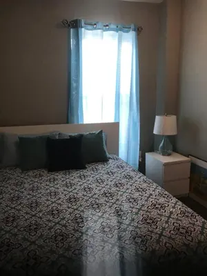 a bedroom with a large bed with a window at Sandy's Place NYC 1 in Brooklyn