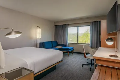 a hotel room with a bed and a desk at Courtyard by Marriott Oneonta in Oneonta