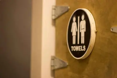 a wooden door with a sign on it with two toilets at American Dream in New York