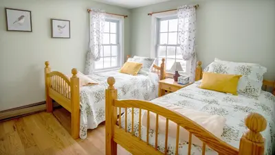 a bedroom with two twin beds and two windows at Cooper Hill Inn in West Dover