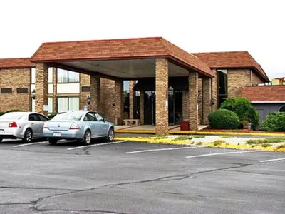 a parking lot with cars parked in front of a building at Travelodge by Wyndham Vernon CT in Vernon
