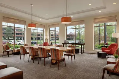 a conference room with a table and chairs and windows at Hilton Garden Inn Stony Brook in Stony Brook