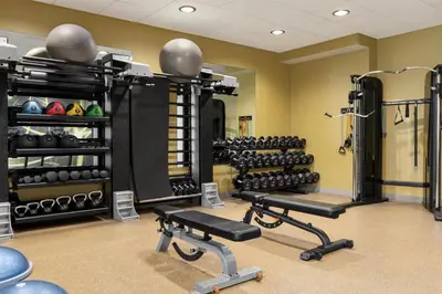 a gym with dumbbells and weights in a room at Hilton Garden Inn Stony Brook in Stony Brook