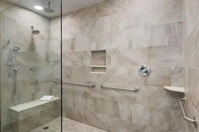 a bathroom with a shower with a glass door at Hilton Garden Inn Stony Brook in Stony Brook
