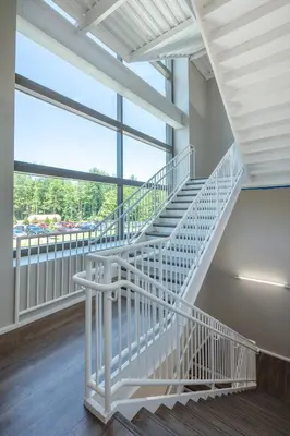 a white staircase in a building with a large window at YO1 Longevity & Health Resorts, Catskills in Monticello