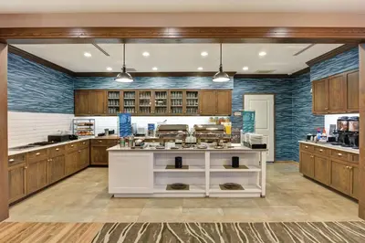 a large kitchen with wooden cabinets and a white island at Homewood Suites By Hilton Hadley Amherst in Hadley
