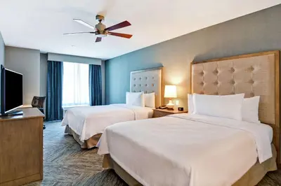 a hotel room with two beds and a flat screen tv at Homewood Suites By Hilton Hadley Amherst in Hadley