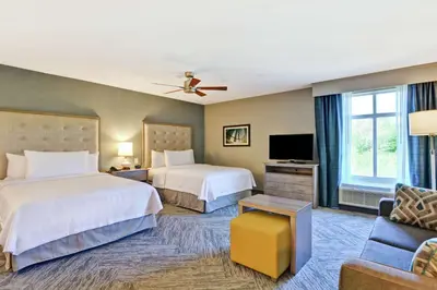 a hotel room with two beds and a couch at Homewood Suites By Hilton Hadley Amherst in Hadley