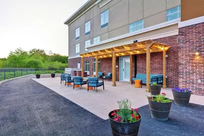 a patio with chairs and tables in front of a building at Homewood Suites By Hilton Hadley Amherst in Hadley