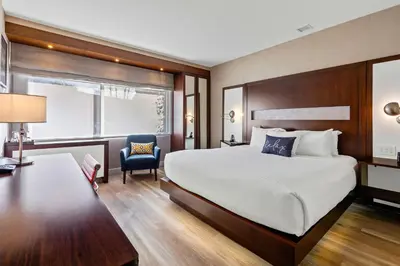a hotel room with a large bed and a chair at The J House Greenwich Hotel in Greenwich