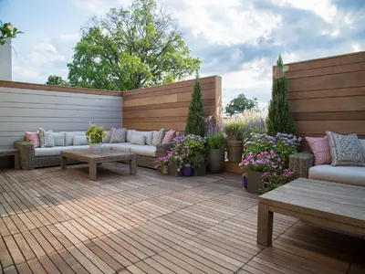 a patio with couches and tables on a wooden deck at The J House Greenwich Hotel in Greenwich