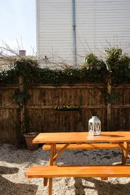 a wooden picnic table in front of a wooden fence at Nest Hudson in Hudson