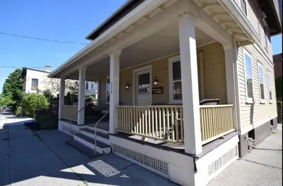 a front porch of a house with a balcony at Nest Hudson in Hudson