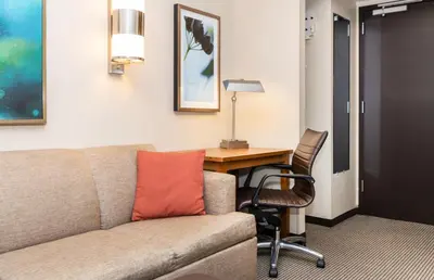 a living room with a couch and a desk at Hyatt Place New York/Midtown-South in New York