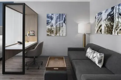 a living room with a couch and a desk at SpringHill Suites by Marriott Tuckahoe Westchester County in Tuckahoe