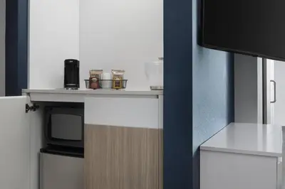 a kitchen with a table with a microwave and a tv at SpringHill Suites by Marriott Tuckahoe Westchester County in Tuckahoe