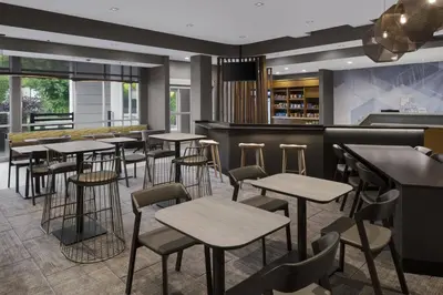a bar with tables and stools in a restaurant at SpringHill Suites by Marriott Tuckahoe Westchester County in Tuckahoe