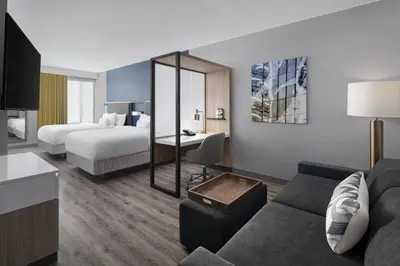 a hotel room with a bed and a couch at SpringHill Suites by Marriott Tuckahoe Westchester County in Tuckahoe