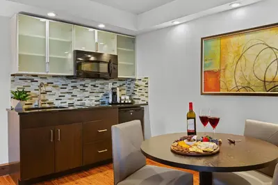 a kitchen and dining room with a table with wine glasses at The Armon Stamford Hotel & Conference Center in Stamford