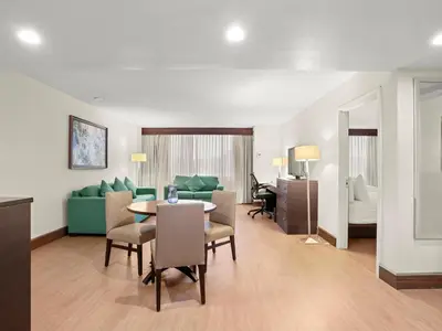a living room with a table and a couch at The Armon Stamford Hotel & Conference Center in Stamford