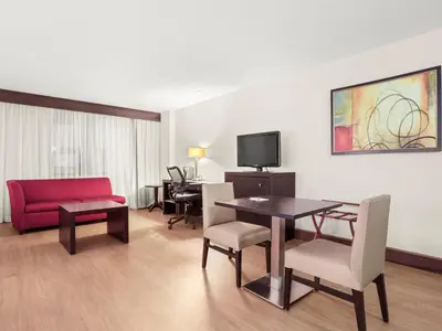 a living room with a table and a red couch at The Armon Stamford Hotel & Conference Center in Stamford