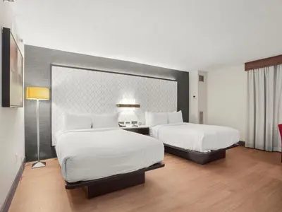 a hotel room with two beds and a lamp at The Armon Stamford Hotel & Conference Center in Stamford