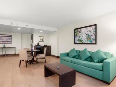 a living room with a blue couch and a table at The Armon Stamford Hotel & Conference Center in Stamford
