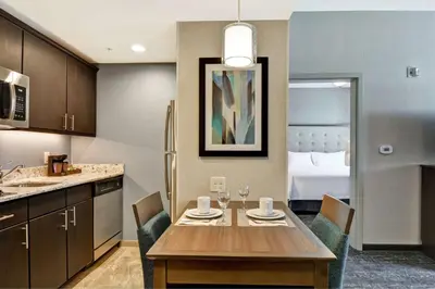 a kitchen with a table and chairs in a room at Homewood Suites By Hilton Poughkeepsie in Poughkeepsie