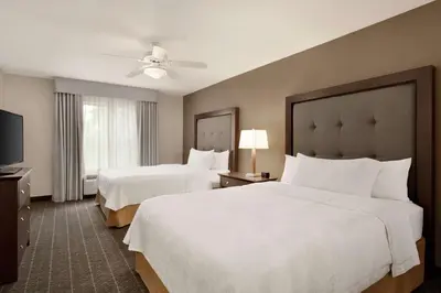 a hotel room with two beds and a flat screen tv at Homewood Suites by Hilton Dover - Rockaway in Dover
