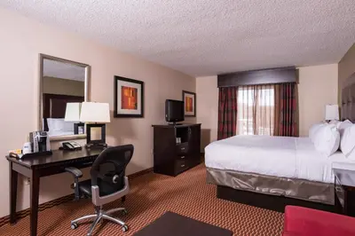 a hotel room with a bed and a desk with a computer at Holiday Inn Express Hartford-Newington by IHG in Newington