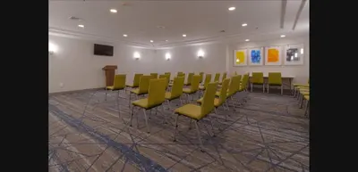a conference room with green chairs and a podium at Holiday Inn Express Hartford-Newington by IHG in Newington