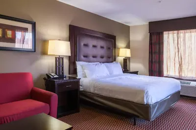 a hotel room with a bed and a red chair at Holiday Inn Express Hartford-Newington by IHG in Newington