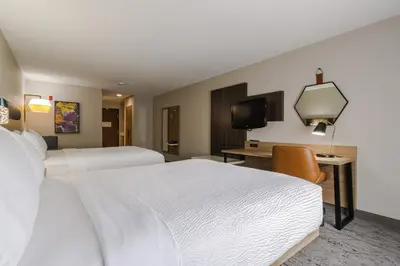 a hotel room with two beds and a desk and a tv at Holiday Inn Express Hartford-Newington by IHG in Newington
