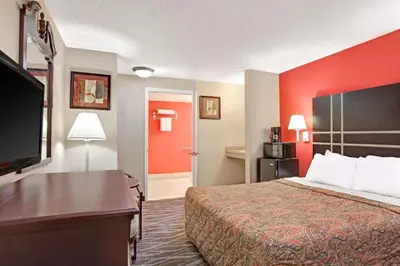 a hotel room with a bed and a flat screen tv at Days Inn by Wyndham Ridgefield NJ in Ridgefield