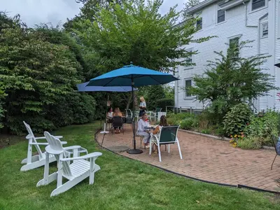 a group of people sitting in chairs under an umbrella at Stanton House Inn in Greenwich