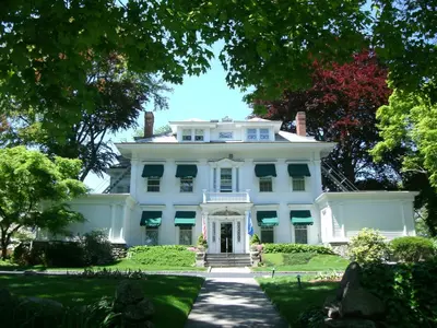 a large white house with a front yard at Stanton House Inn in Greenwich