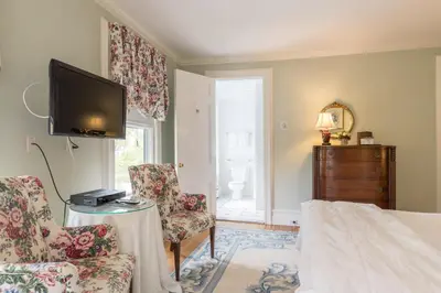 a living room with two chairs and a television at Stanton House Inn in Greenwich