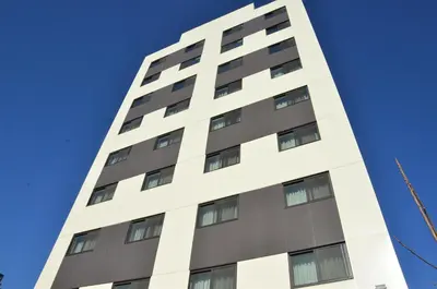 a tall white building against a blue sky at LIC Plaza Hotel in Queens
