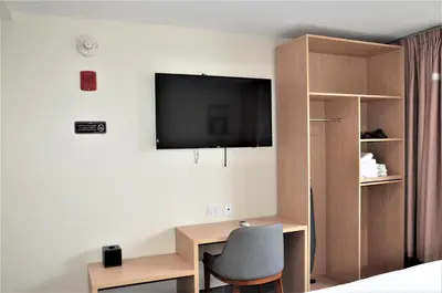 a room with a desk and a television on the wall at LIC Plaza Hotel in Queens