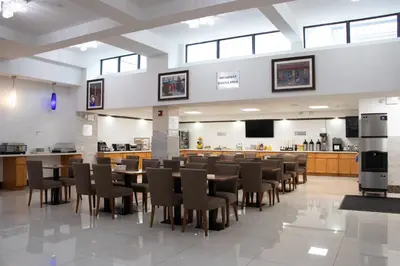 a large dining room with tables and chairs at LIC Plaza Hotel in Queens
