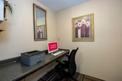 a room with a desk with a computer and a chair at Red Roof Inn Clifton Park in Clifton Park