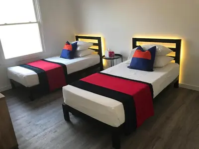 two beds in a room with a window at Modern GuestHouse Ironbound Newark with KITCHEN-FastTrainToNYC-OneStopToAirport in Newark
