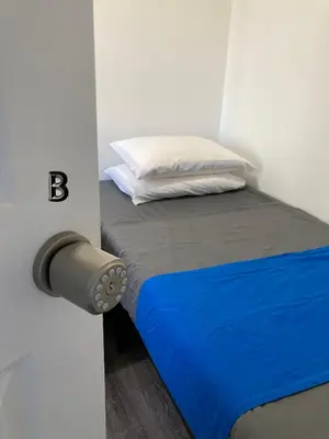 a small bedroom with a bed with a pillow at Modern GuestHouse Ironbound Newark with KITCHEN-FastTrainToNYC-OneStopToAirport in Newark