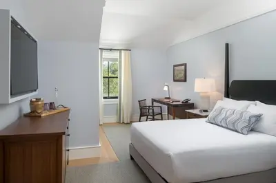 a bedroom with a bed and a desk and a television at The Williams Inn in Williamstown