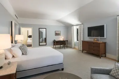 a bedroom with a bed and a desk and a tv at The Williams Inn in Williamstown