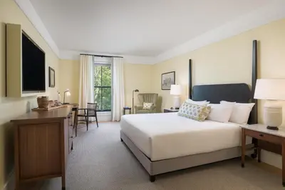 a bedroom with a large white bed and a desk at The Williams Inn in Williamstown