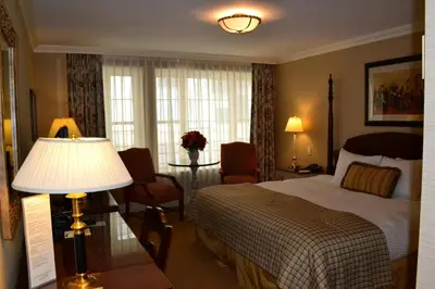 a hotel room with a bed and a table with a lamp at The Wall Street Inn in New York